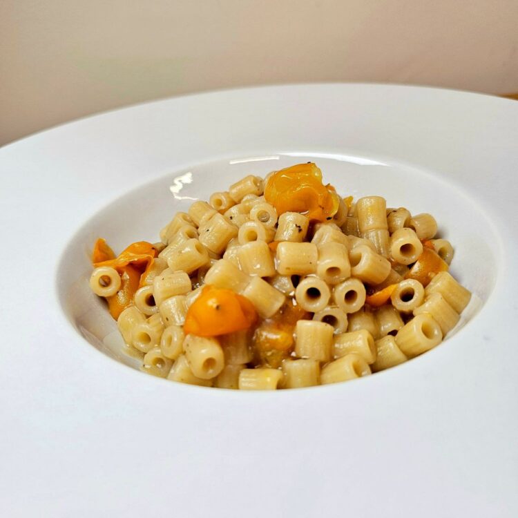 Pasta con crema di patate viola e datterino giallo in acqua di mare