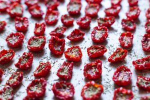 Pomodori Fiaschetto di Torre Guacedo freschi pronti per essere trasformati in pomodori semisecchi." Pomodori semisecchi di Torre Guacedo in un piatto tipico pugliese